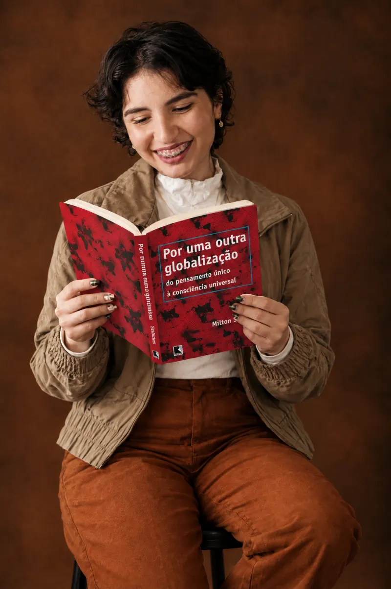 Luana lendo o livro Por uma outra globalização, de Milton Santos, em estúdio